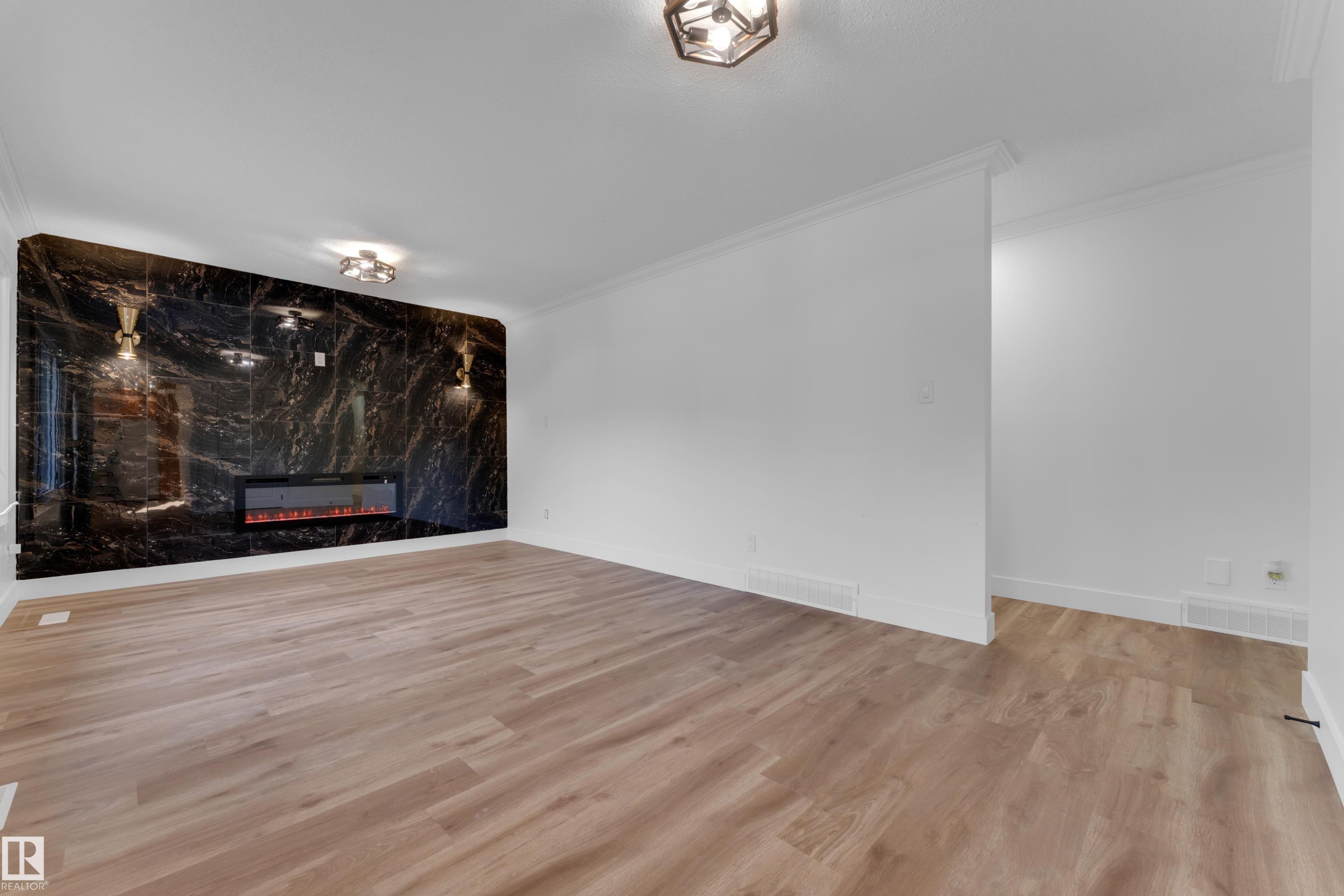 Wood-finish flooring, crown molding, electric fireplace, accent wall with dark veining, and recessed lighting - 52314 Rge Road 215, Rural Strathcona County, AB