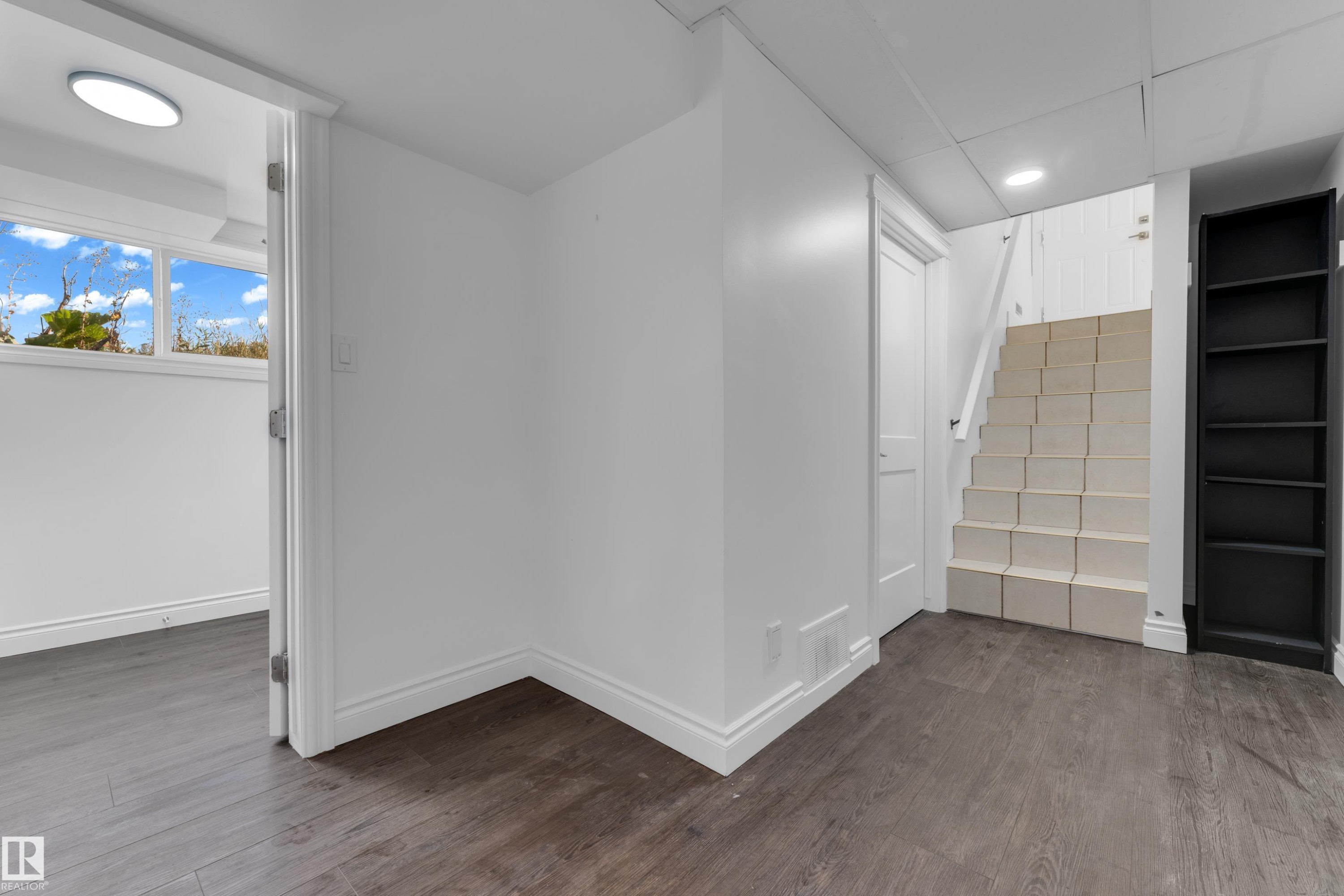 Wood-finish flooring, white painted walls, white trim, recessed lighting, and a built-in shelving unit - 52314 Rge Road 215, Rural Strathcona County, AB