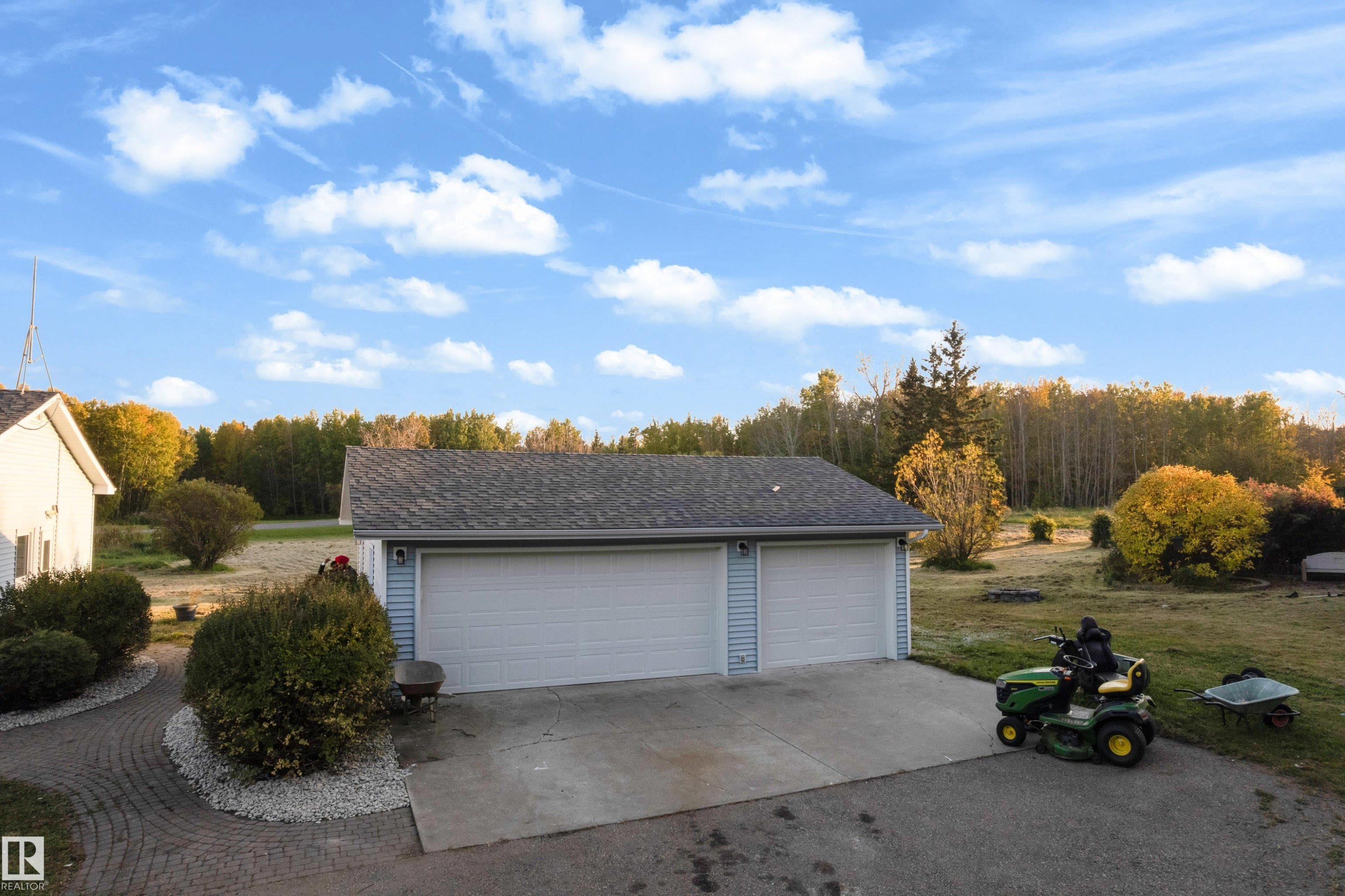 Detached garage with two white overhead doors and light blue siding, asphalt shingle roof - 52314 Rge Road 215, Rural Strathcona County, AB