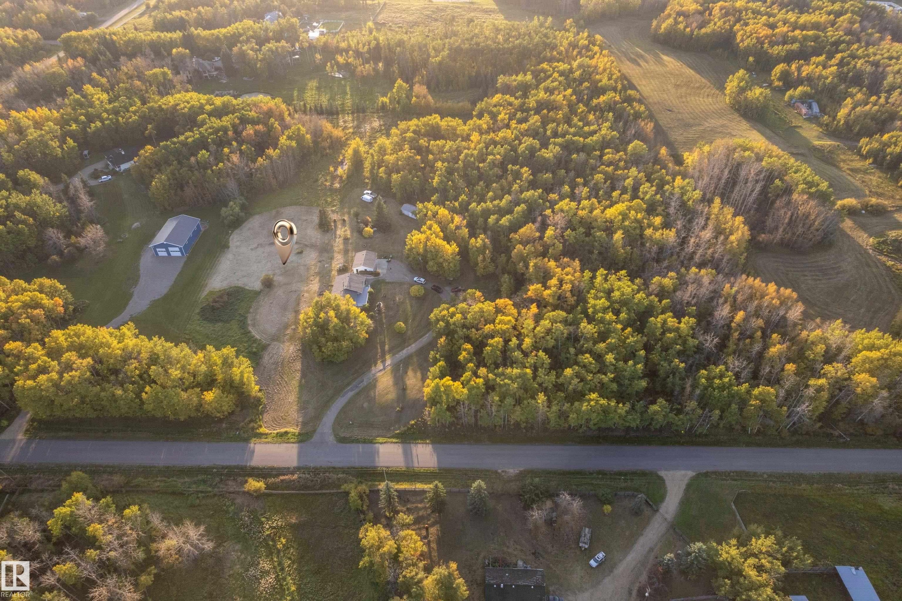 Expansive lot with mature trees, a detached outbuilding, and a paved driveway - 52314 Rge Road 215, Rural Strathcona County, AB
