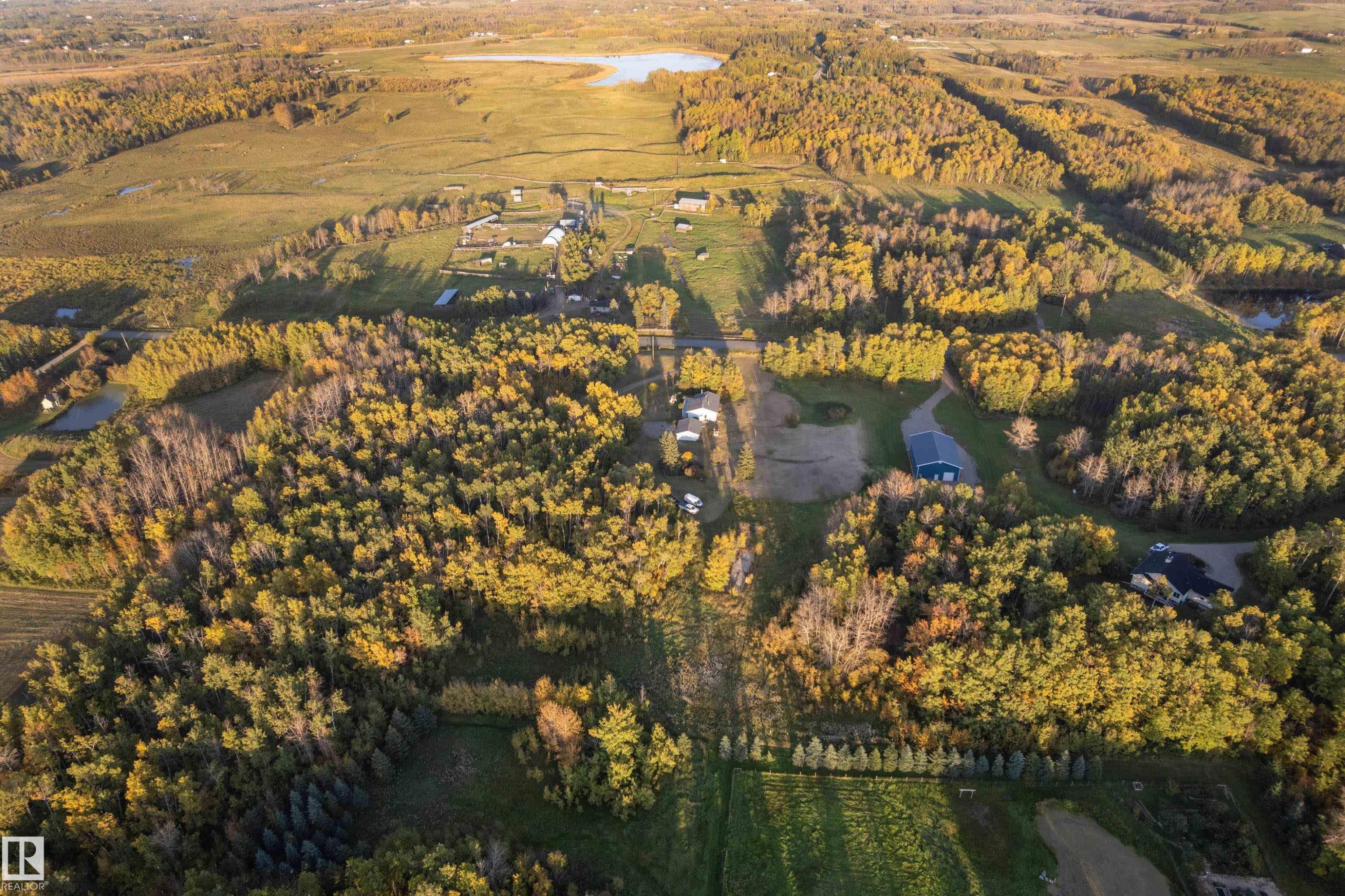 Expansive natural landscape featuring lush trees, open fields, and multiple bodies of water - 52314 Rge Road 215, Rural Strathcona County, AB