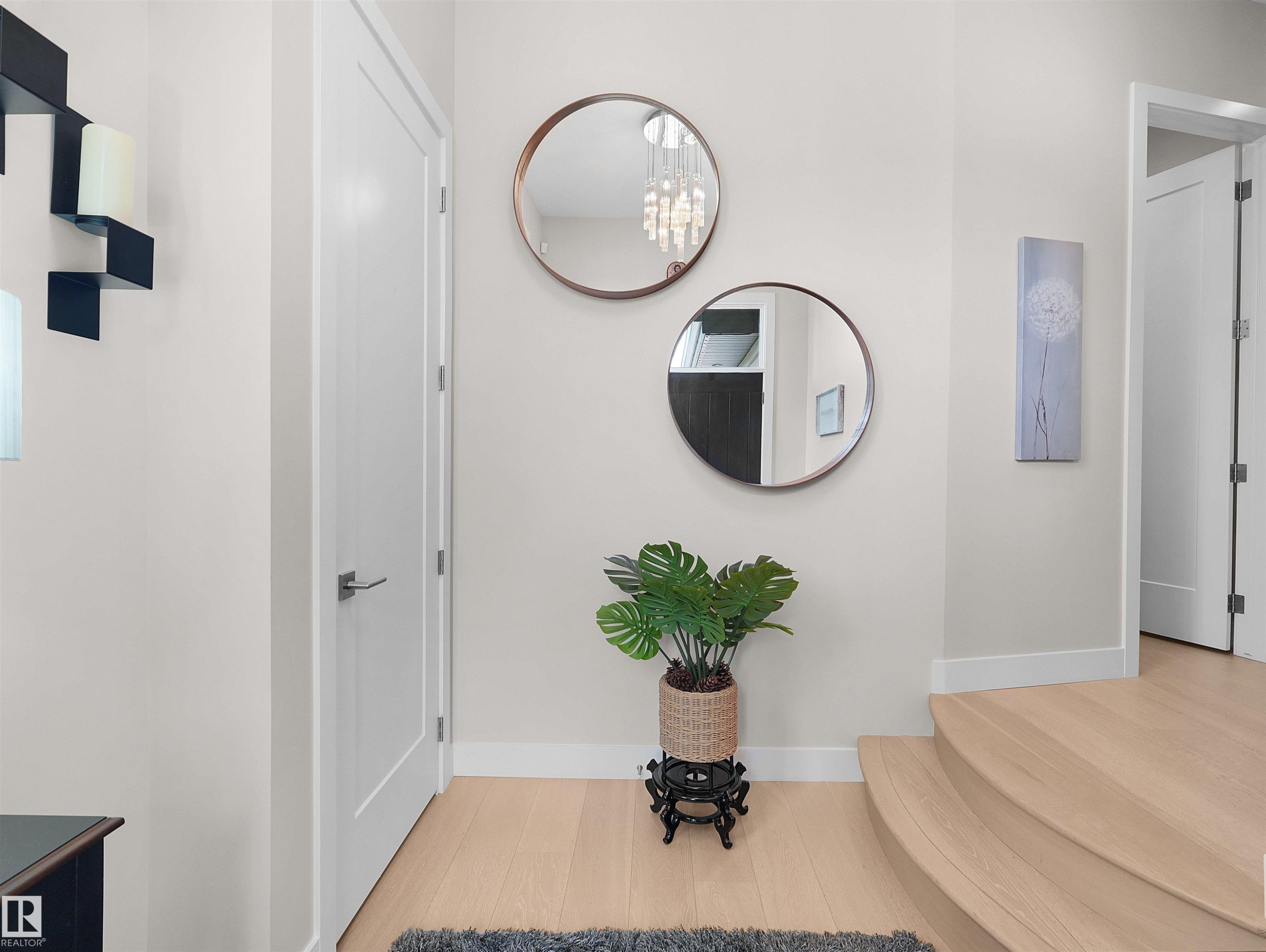 Light wood-finish flooring, white flat-panel doors with matte hardware, and curved stair treads - 904 Wood Place Nw, Edmonton, AB