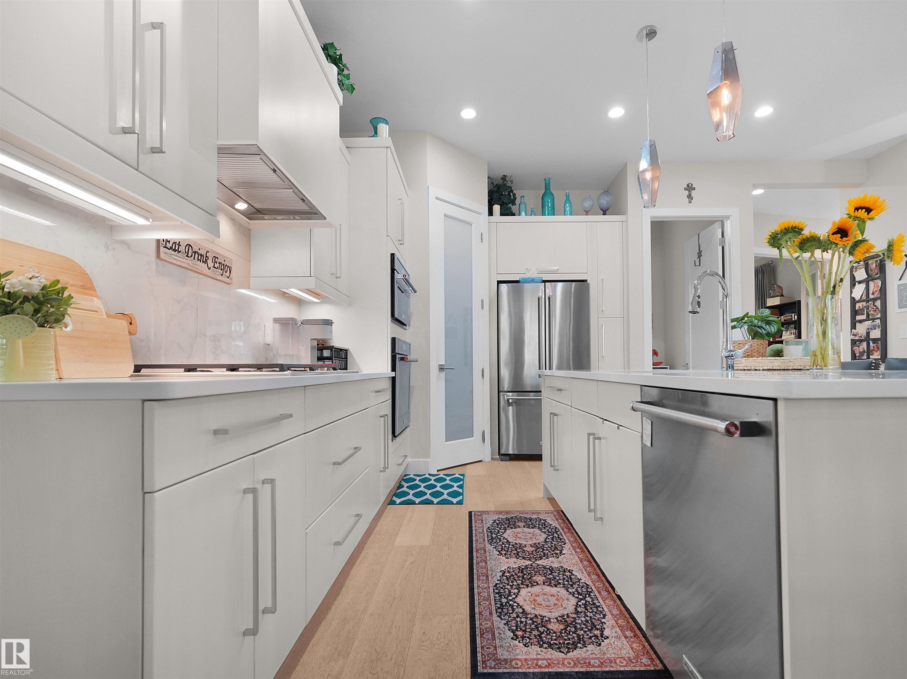 White cabinetry, stainless steel appliances, light wood-finish flooring, recessed lighting, and pendant lighting - 904 Wood Place Nw, Edmonton, AB