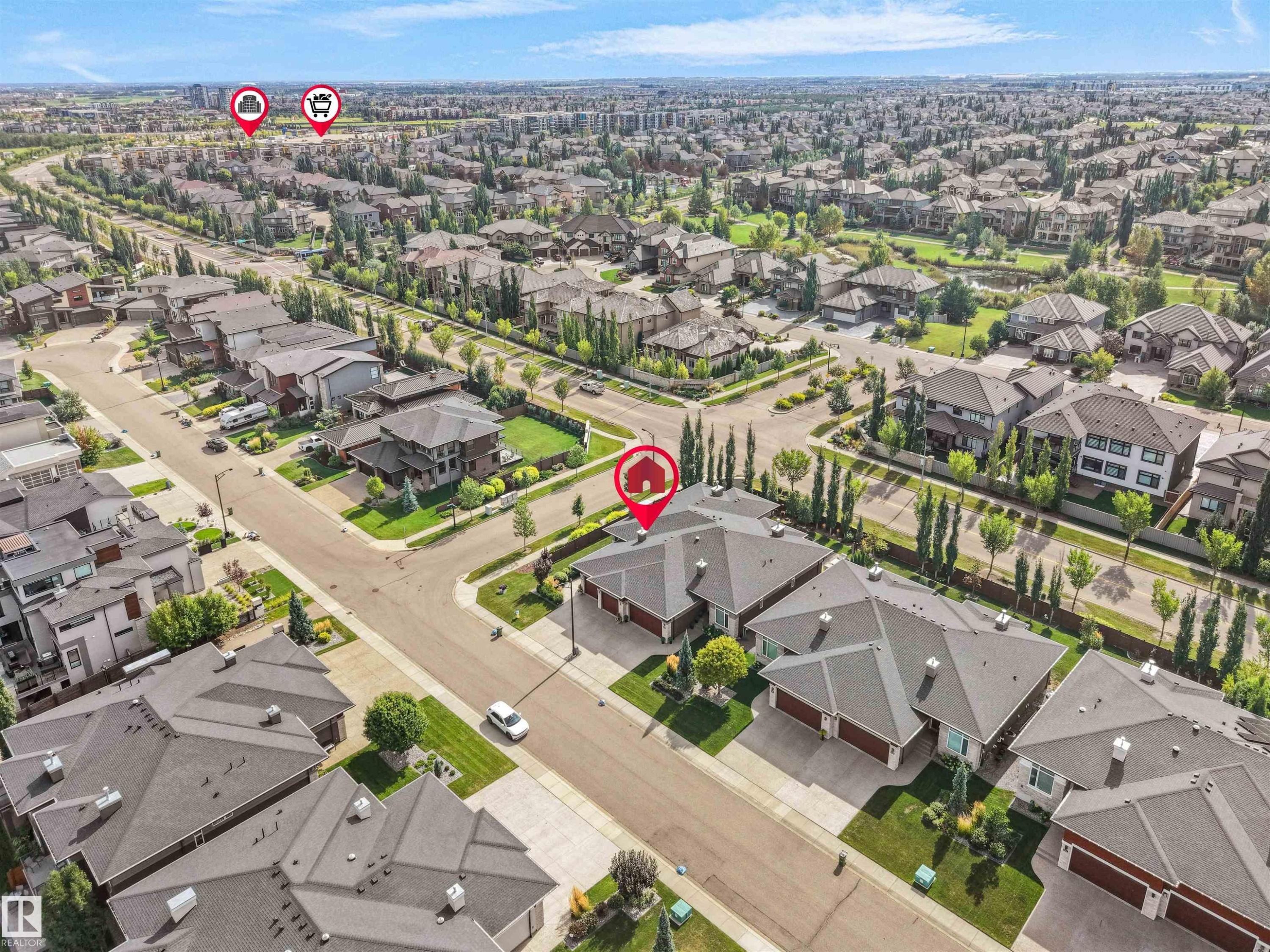 Residential area featuring numerous houses with dark shingle roofs, mature trees, and paved streets - 904 Wood Place Nw, Edmonton, AB