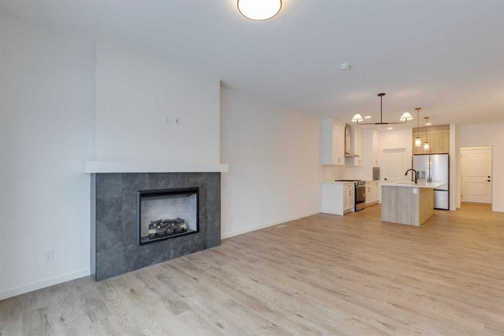 1402 Bayview Crescent Sw, Airdrie, AB - Indoor Photo Showing Other Room With Fireplace