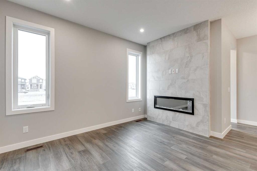483 Hotchkiss Manor Se, Calgary, AB - Indoor Photo Showing Living Room With Fireplace