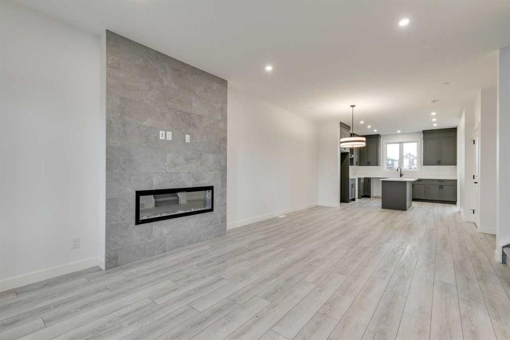 479 Hotchkiss Manor Se, Calgary, AB - Indoor Photo Showing Other Room With Fireplace