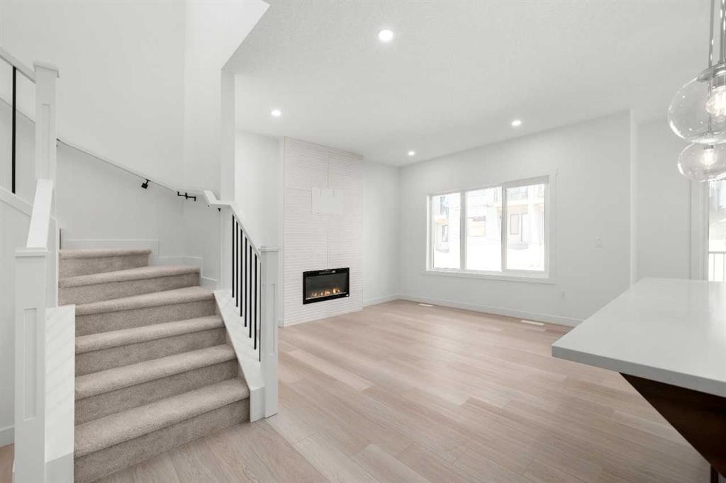 87 Heritage Manor, Cochrane, AB - Indoor Photo Showing Other Room With Fireplace