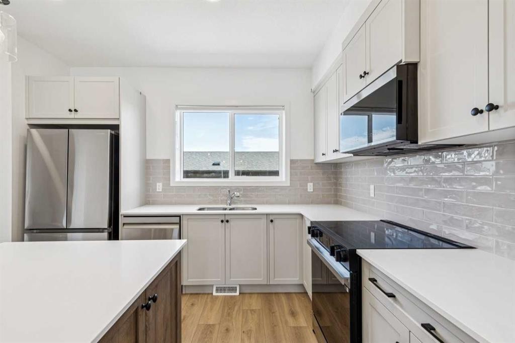 15 Emberside Park, Cochrane, AB - Indoor Photo Showing Kitchen With Double Sink With Upgraded Kitchen