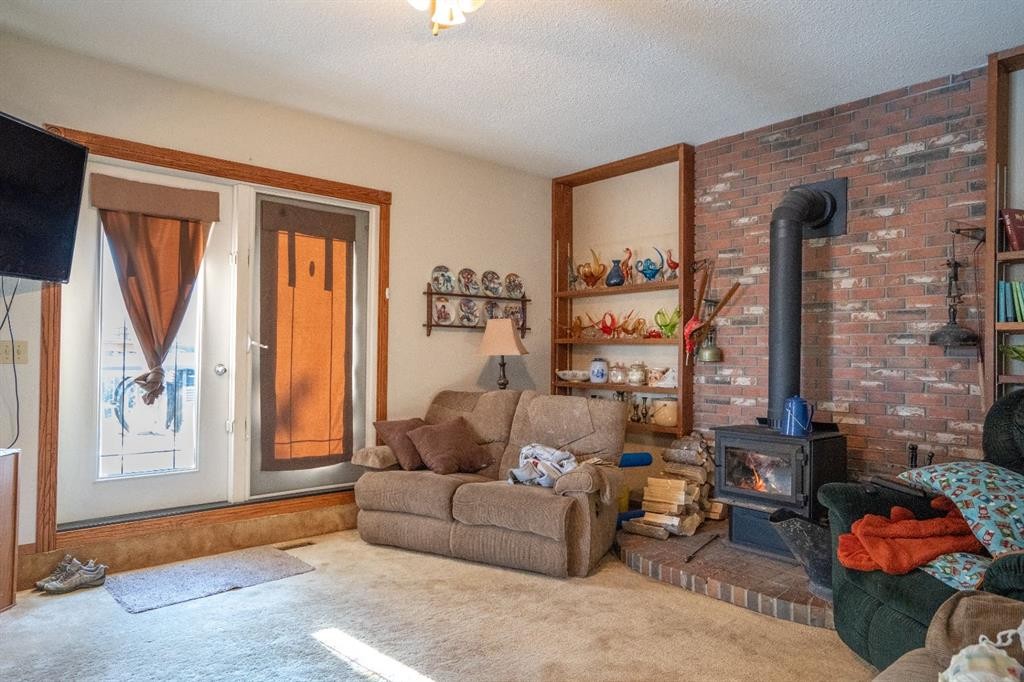 4908 47 Street, Clive, AB - Indoor Photo Showing Living Room With Fireplace