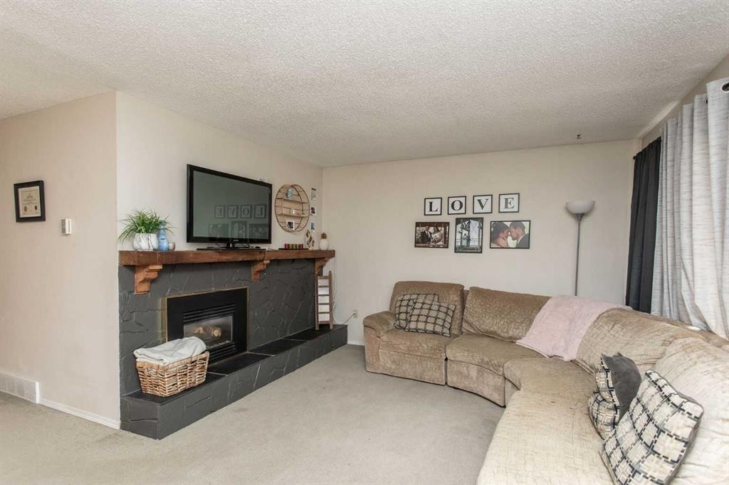 10 Valley Crescent, Lacombe, AB - Indoor Photo Showing Living Room With Fireplace