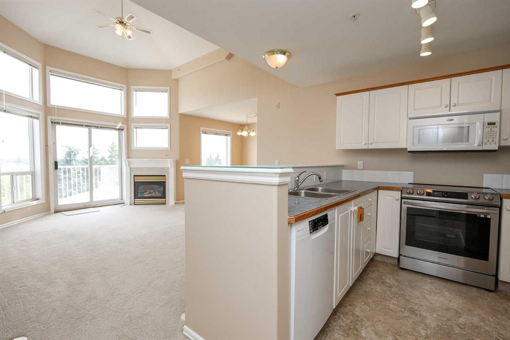 409-6118 53 Avenue, Red Deer, AB - Indoor Photo Showing Kitchen With Fireplace With Double Sink