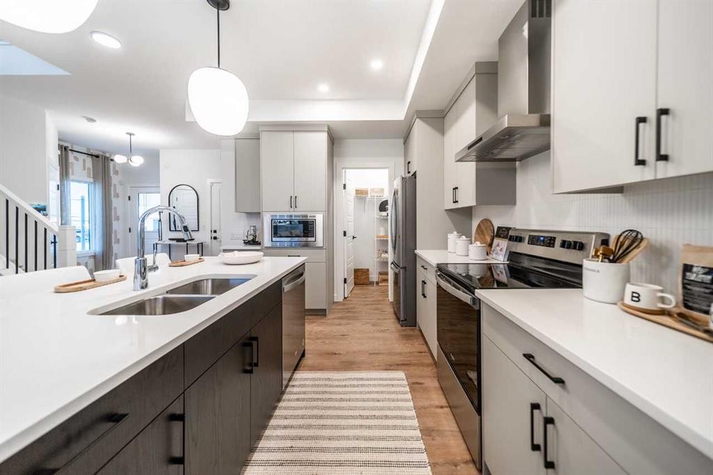 52 Southborough Common, Cochrane, AB - Indoor Photo Showing Kitchen With Double Sink With Upgraded Kitchen
