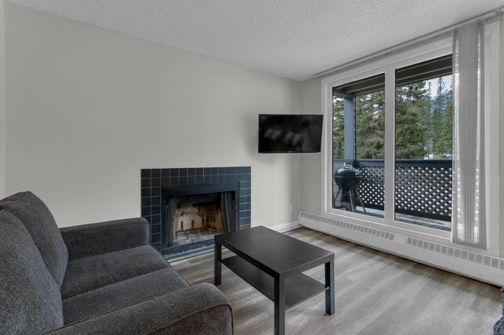 111-414 Squirrel Street, Banff, AB - Indoor Photo Showing Living Room With Fireplace