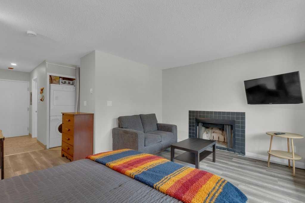 111-414 Squirrel Street, Banff, AB - Indoor Photo Showing Living Room With Fireplace
