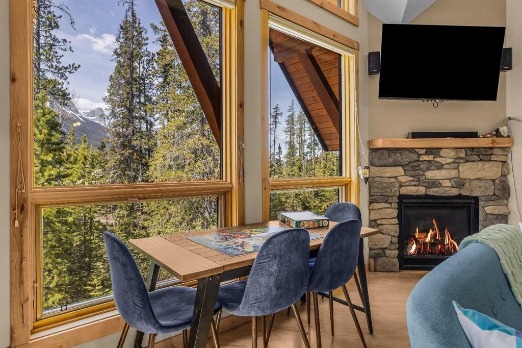 302-2100A Stewart Creek Drive, Canmore, AB - Indoor Photo Showing Dining Room With Fireplace