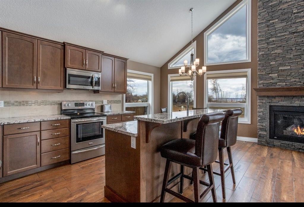 # 219 162 Peace River Avenue, Joussard, AB - Indoor Photo Showing Kitchen With Fireplace With Stainless Steel Kitchen