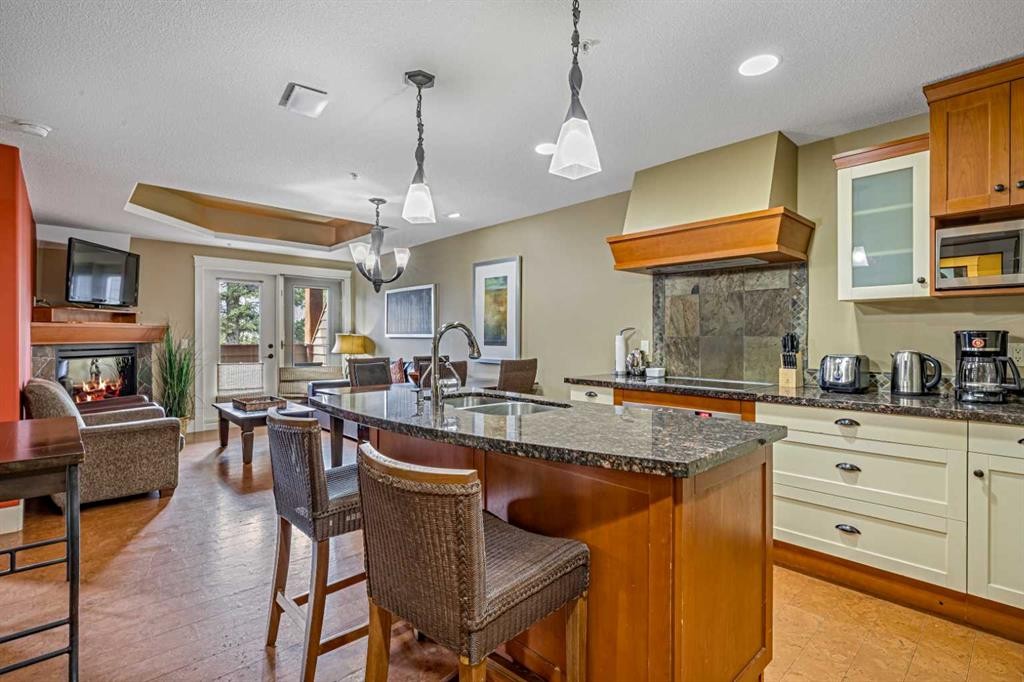 305L-191 Kananaskis, Canmore, AB - Indoor Photo Showing Kitchen With Fireplace With Double Sink
