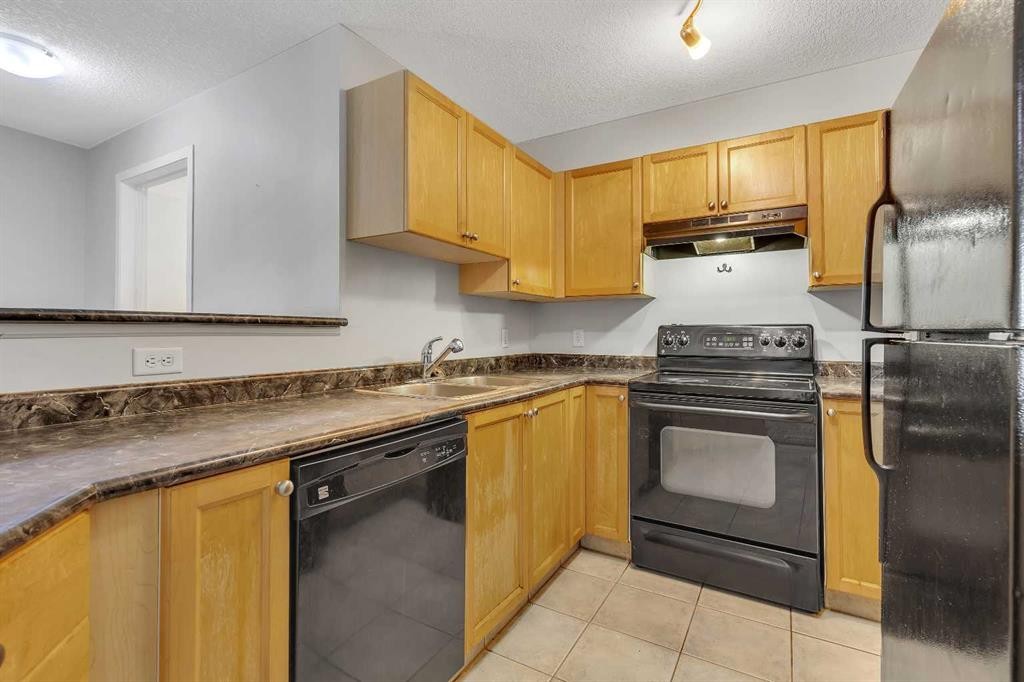 6307-304 Mackenzie Way Sw, Airdrie, AB - Indoor Photo Showing Kitchen With Double Sink