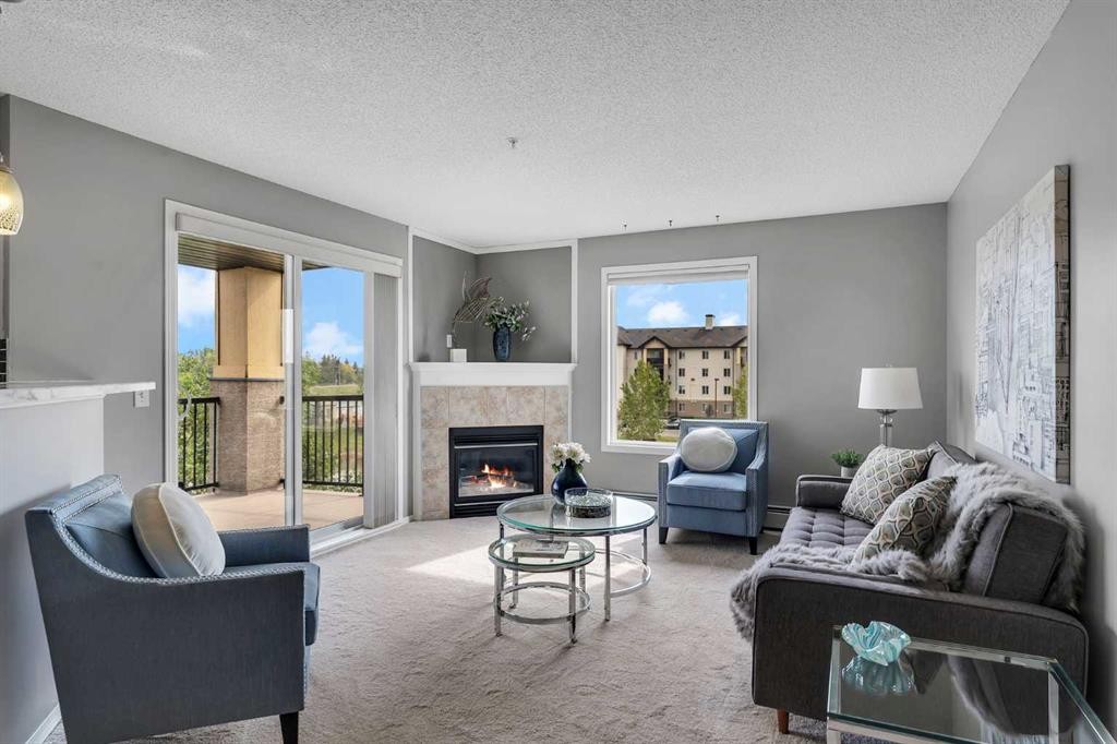 8328-304 Mackenzie Way Sw, Airdrie, AB - Indoor Photo Showing Living Room With Fireplace