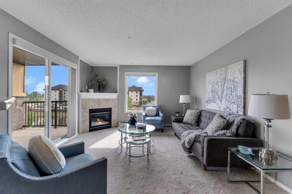 8328-304 Mackenzie Way Sw, Airdrie, AB - Indoor Photo Showing Living Room With Fireplace