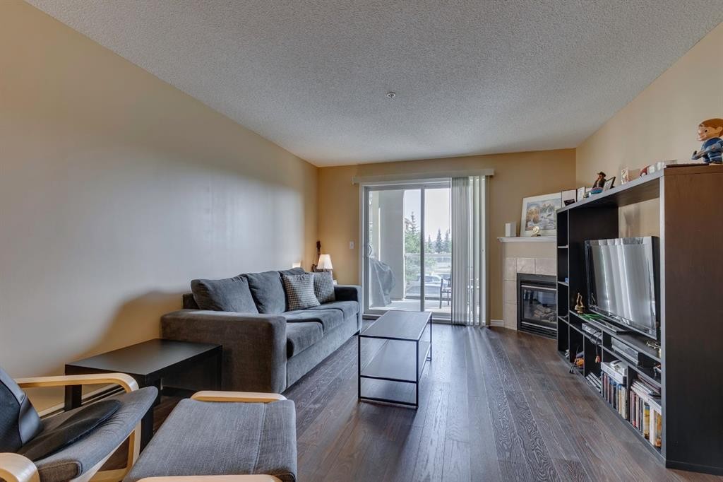 2205-2518 Fish Creek Boulevard Sw, Calgary, AB - Indoor Photo Showing Living Room With Fireplace