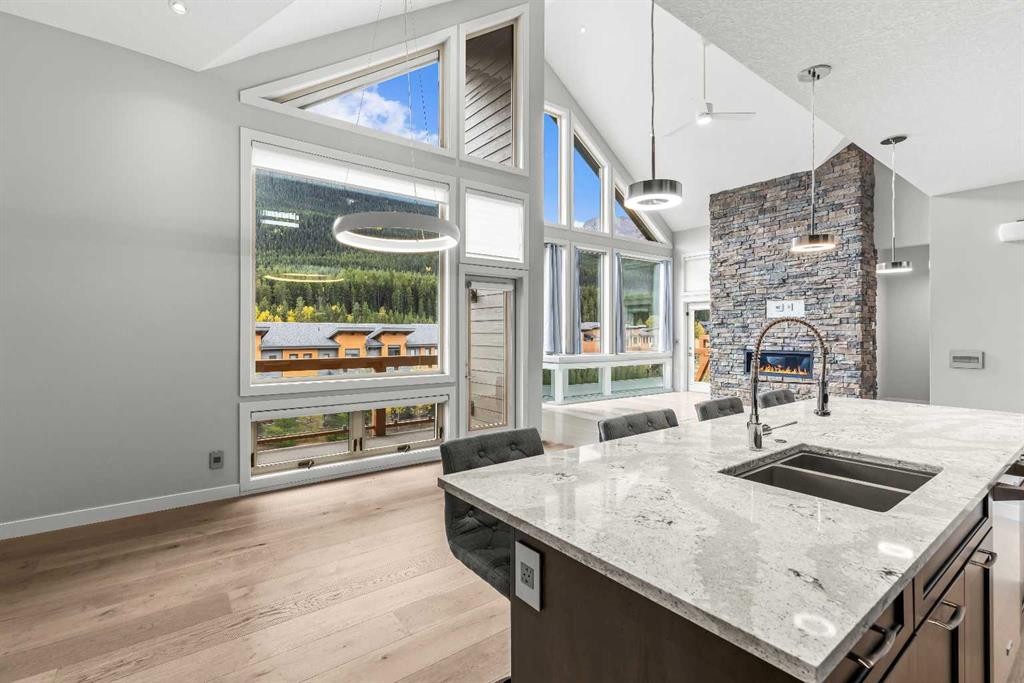 204-105 Stewart Creek Rise Sw, Canmore, AB - Indoor Photo Showing Kitchen With Fireplace With Double Sink