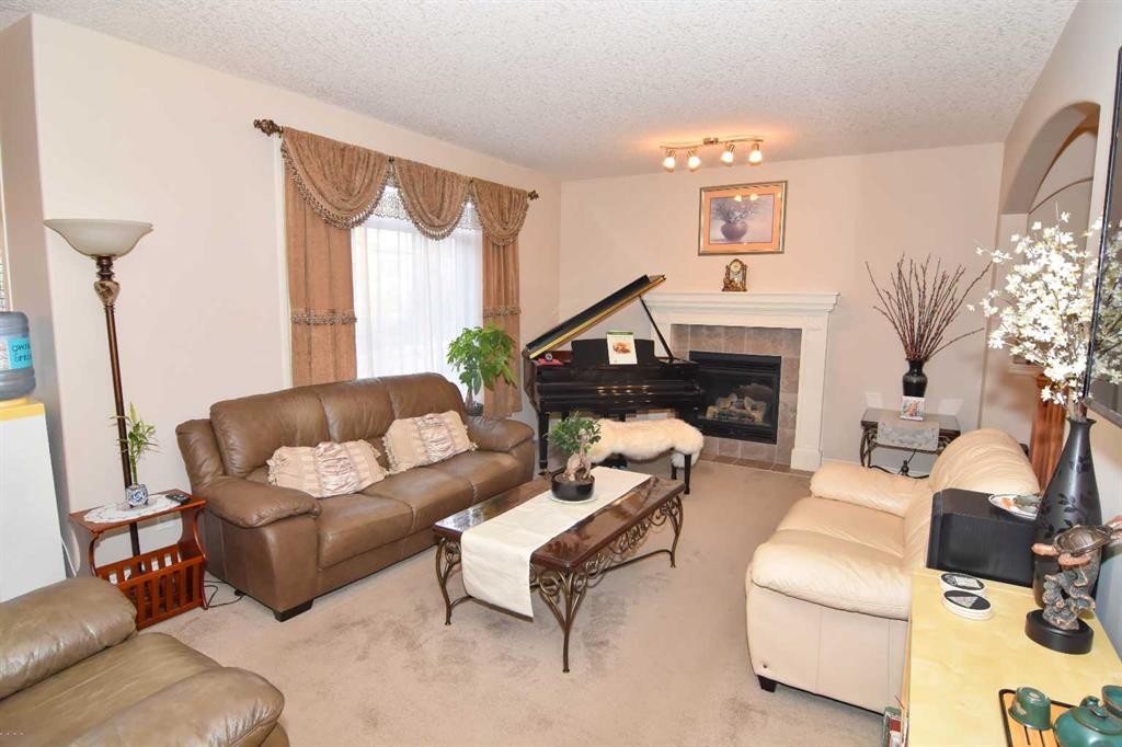 107 Panatella Close Nw, Calgary, AB - Indoor Photo Showing Living Room With Fireplace