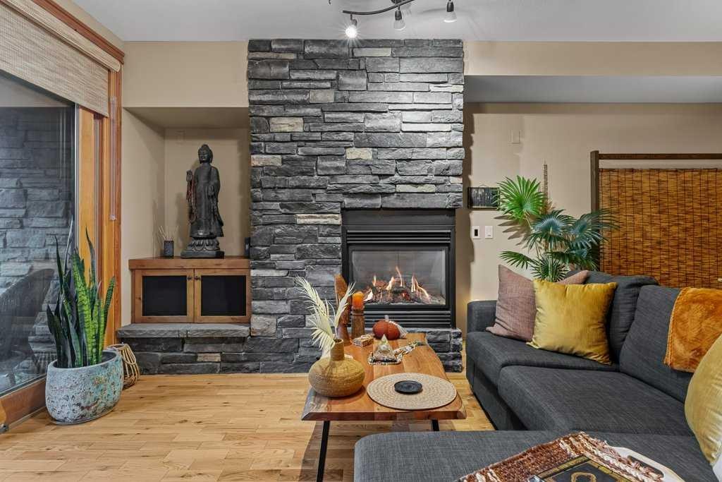 2107-101B Stewart Creek Landing, Canmore, AB - Indoor Photo Showing Living Room With Fireplace