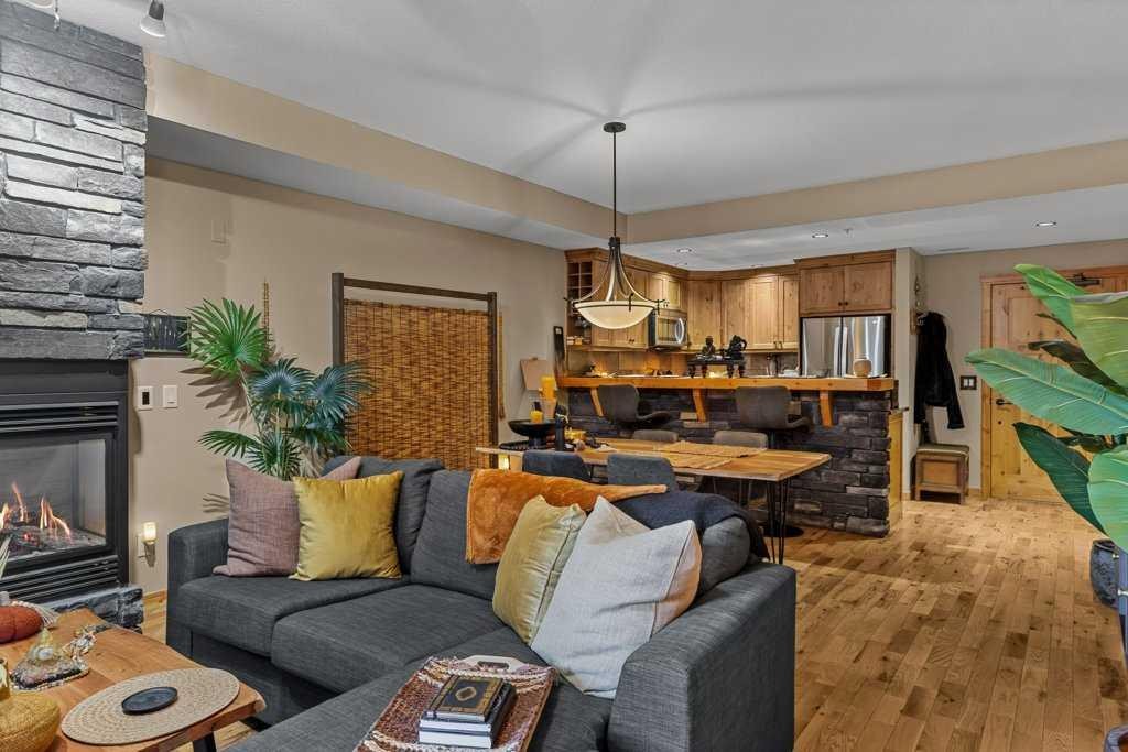 2107-101B Stewart Creek Landing, Canmore, AB - Indoor Photo Showing Living Room With Fireplace