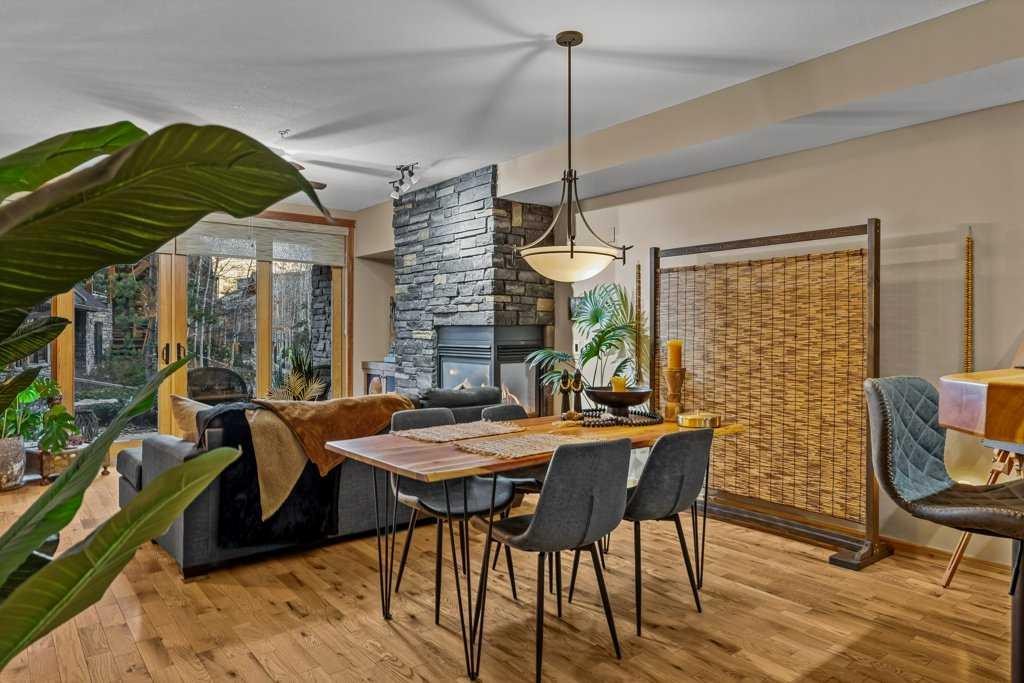 2107-101B Stewart Creek Landing, Canmore, AB - Indoor Photo Showing Dining Room With Fireplace