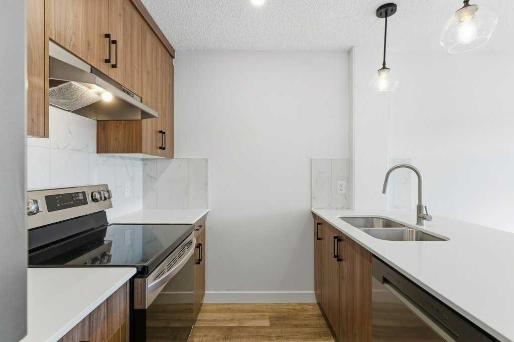 102-156 Park Street, Cochrane, AB - Indoor Photo Showing Kitchen With Double Sink