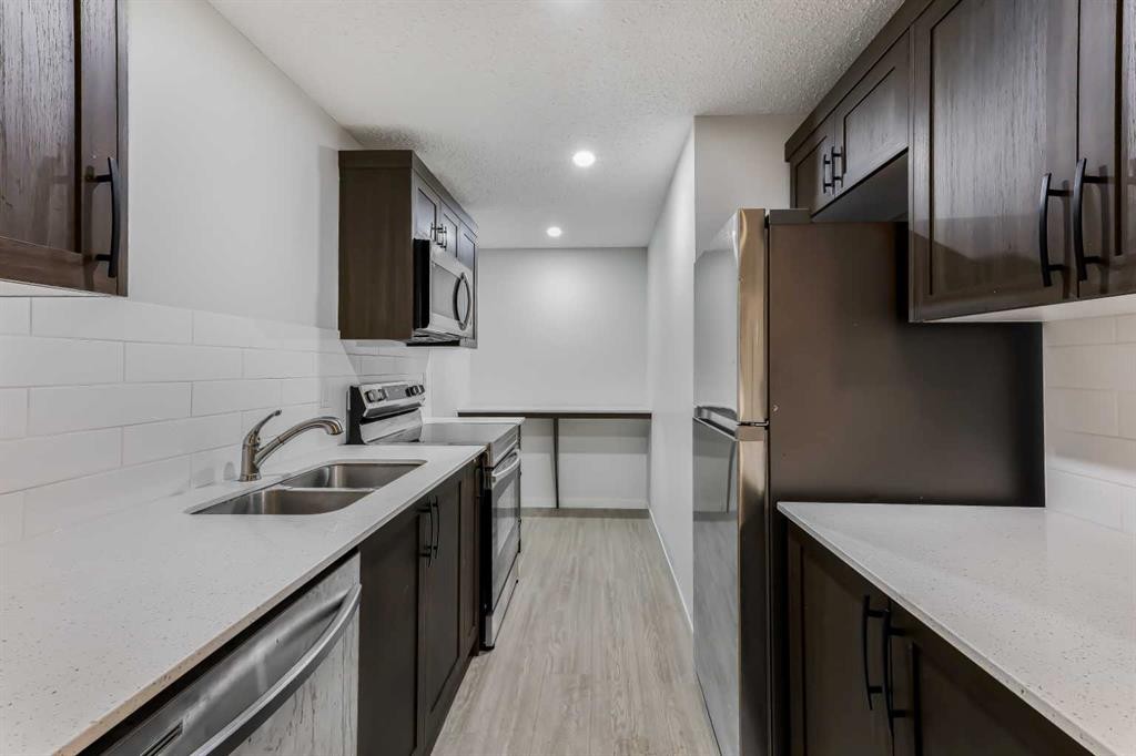 15 Edith Passage Nw, Calgary, AB - Indoor Photo Showing Kitchen With Double Sink