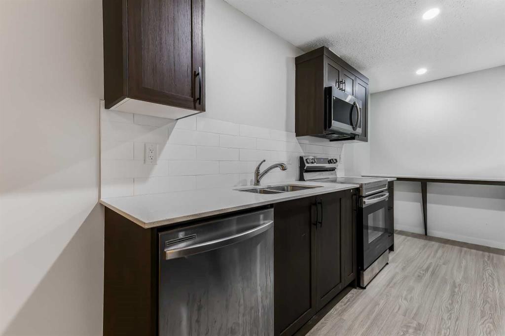 15 Edith Passage Nw, Calgary, AB - Indoor Photo Showing Kitchen With Double Sink