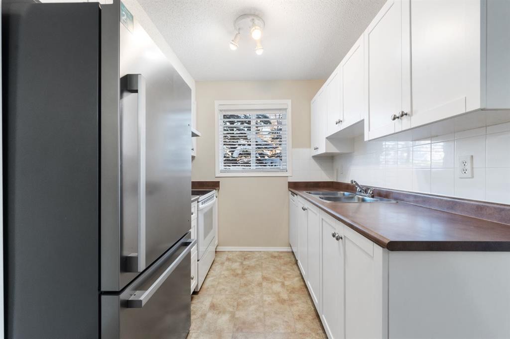 1102-2395 Eversyde Avenue Sw, Calgary, AB - Indoor Photo Showing Kitchen With Double Sink
