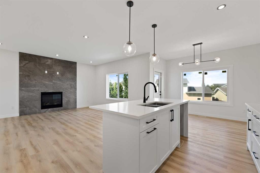 9 Mcclung Gate, Carstairs, AB - Indoor Photo Showing Kitchen With Fireplace With Double Sink With Upgraded Kitchen