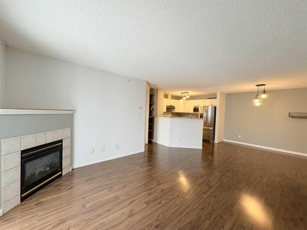 #418-4000 Somervale Court Sw, Calgary, AB - Indoor Photo Showing Living Room With Fireplace