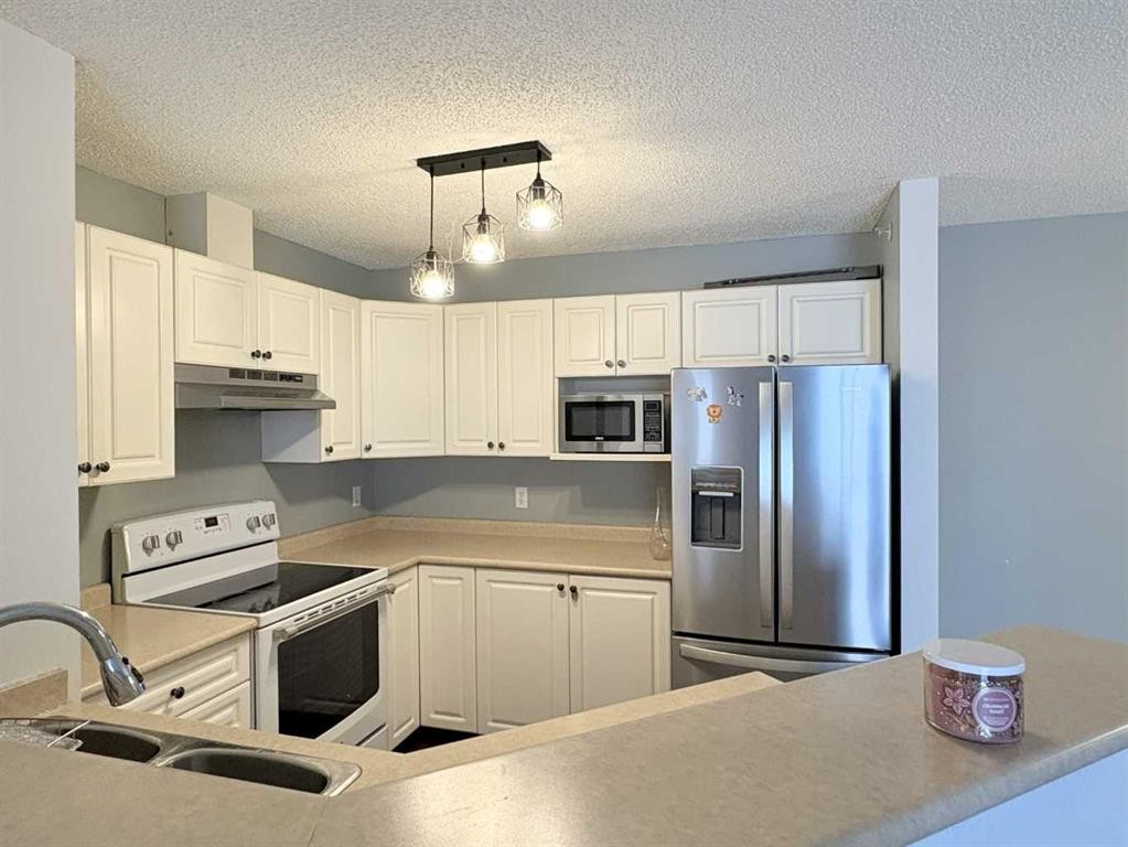 #418-4000 Somervale Court Sw, Calgary, AB - Indoor Photo Showing Kitchen With Double Sink