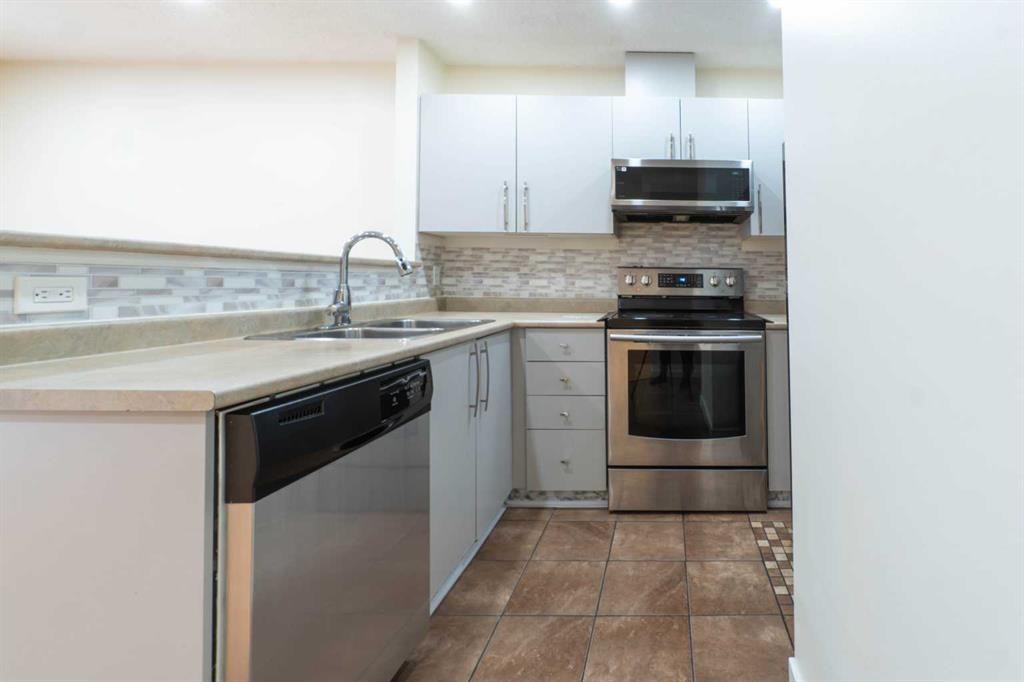 204-760 Railway Gate Sw, Airdrie, AB - Indoor Photo Showing Kitchen With Stainless Steel Kitchen With Double Sink