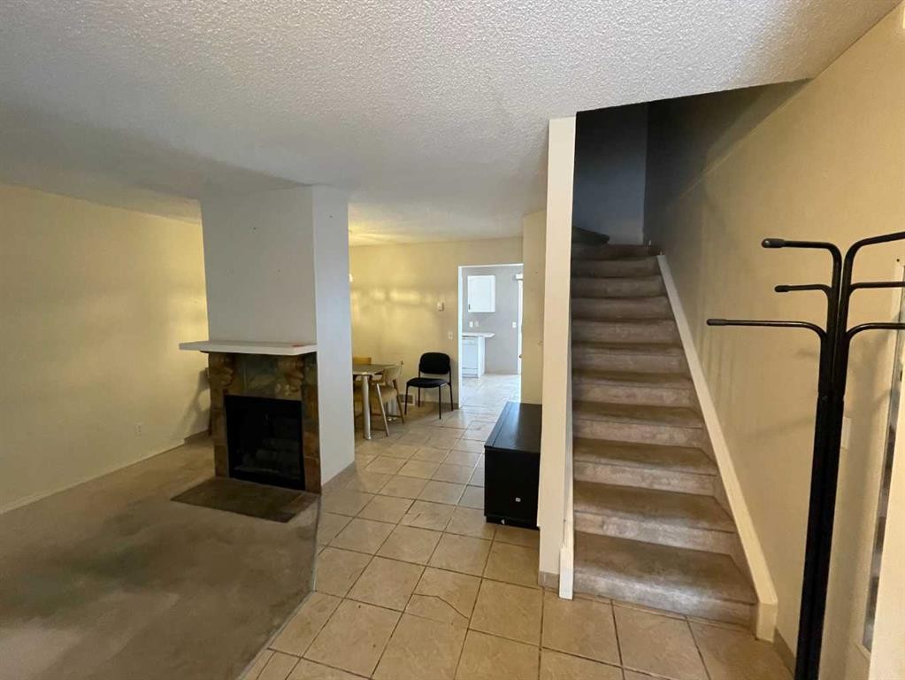 68 Abbeydale Villas Ne, Calgary, AB - Indoor Photo Showing Other Room With Fireplace