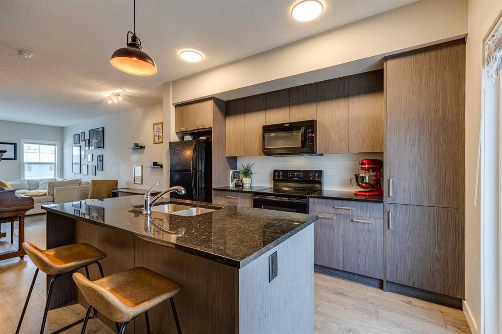 2103 Jumping Pound Common, Cochrane, AB - Indoor Photo Showing Kitchen With Double Sink