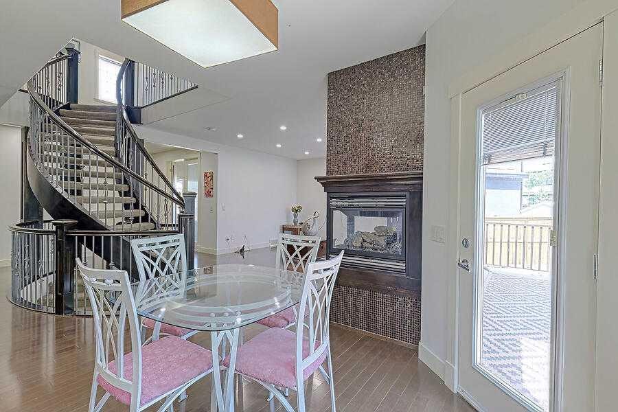 16 Rockcliff Point Nw, Calgary, AB - Indoor Photo Showing Dining Room With Fireplace