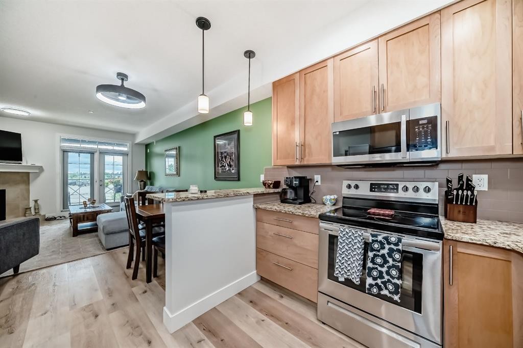 111-1005B Westmount Drive, Strathmore, AB - Indoor Photo Showing Kitchen With Fireplace