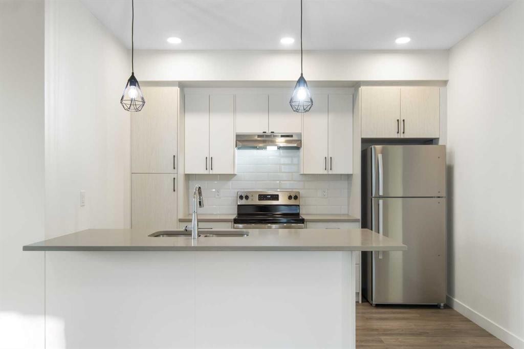 1301-24 Rivercrest Drive, Cochrane, AB - Indoor Photo Showing Kitchen With Double Sink With Upgraded Kitchen