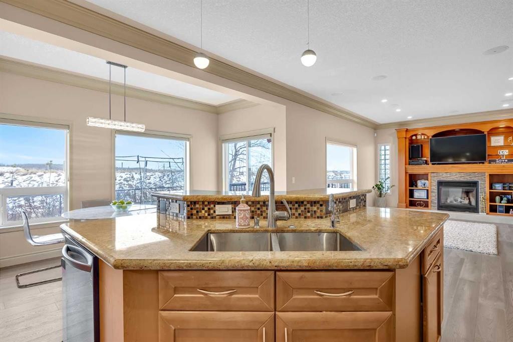 100 Cougarstone Manor Sw, Calgary, AB - Indoor Photo Showing Kitchen With Fireplace With Double Sink
