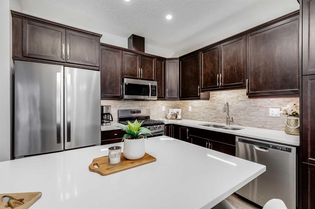 22 Osborne Common Sw, Airdrie, AB - Indoor Photo Showing Kitchen With Stainless Steel Kitchen With Double Sink With Upgraded Kitchen
