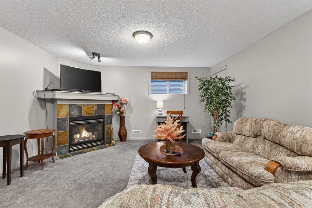 331 Prestwick Heights Se, Calgary, AB - Indoor Photo Showing Living Room With Fireplace