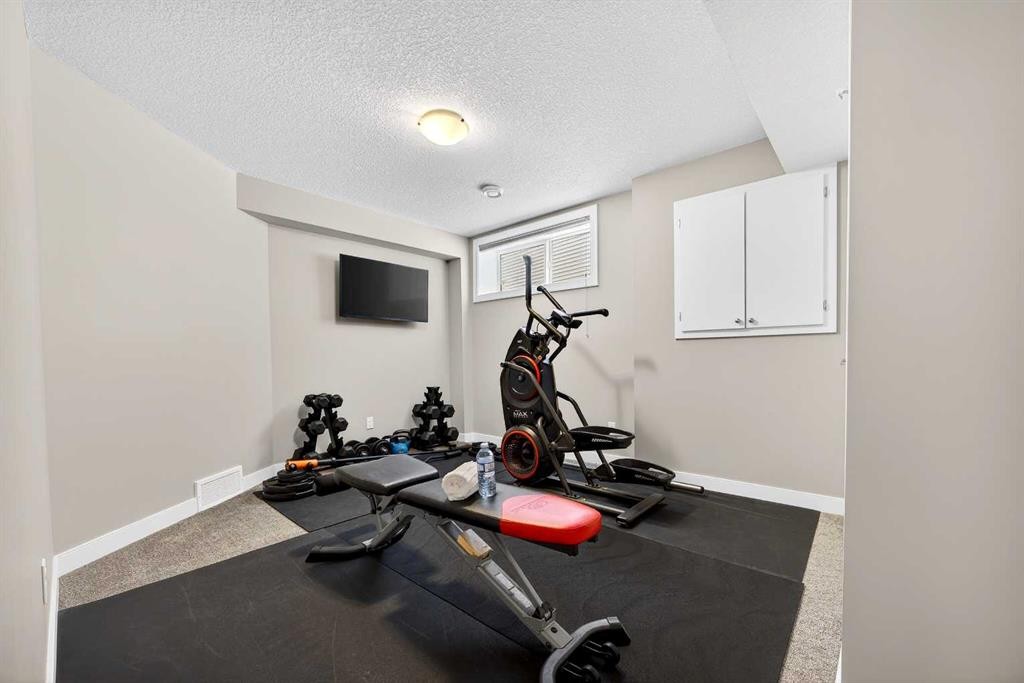 144 Sundown View, Cochrane, AB - Indoor Photo Showing Gym Room