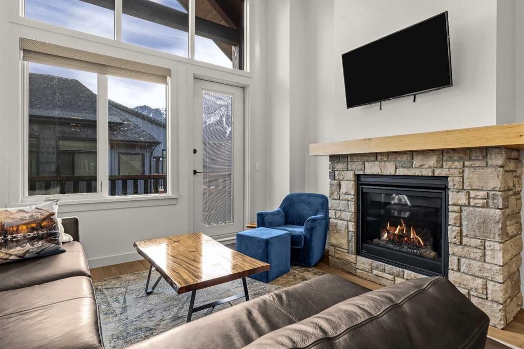402-1315 Spring Creek Gate, Canmore, AB - Indoor Photo Showing Living Room With Fireplace
