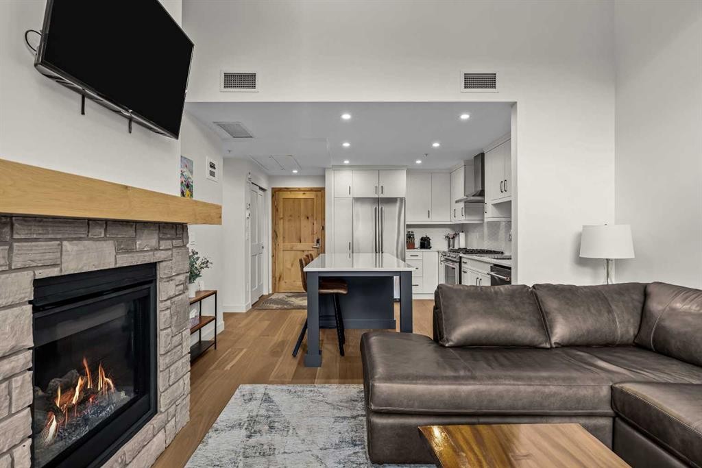 402-1315 Spring Creek Gate, Canmore, AB - Indoor Photo Showing Living Room With Fireplace